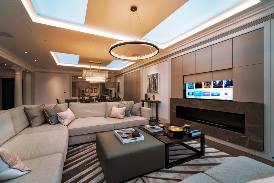 A living room with a TV emerging from behind a Future Automation panel.